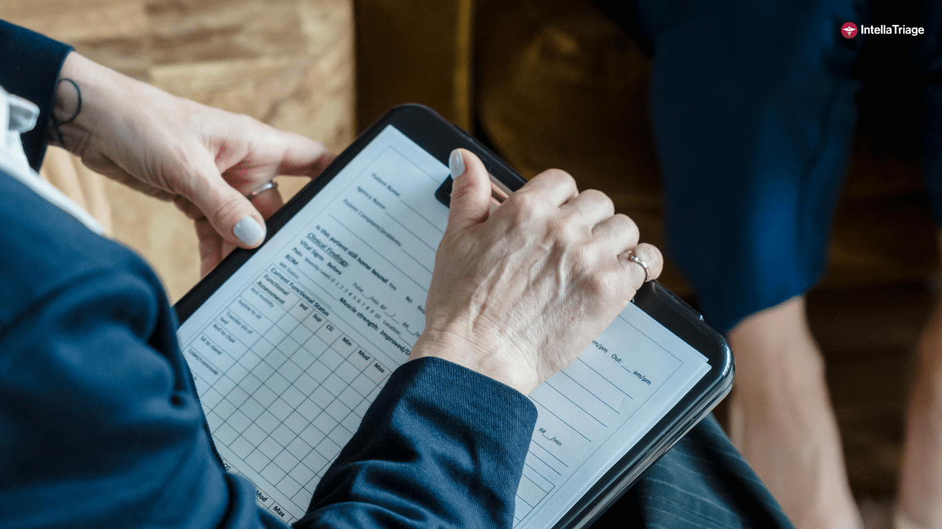 A Person Holding a Clipboard With a Health Assessment Checklist Caross From Someone Seated. IntellaTriage Logo Is Featured.